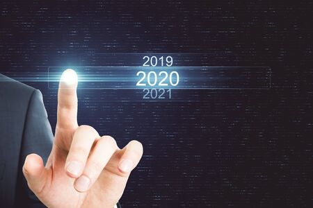 Businessman pointing at glowing digital 2020 touchscreen. Future and innovation conceptの写真素材