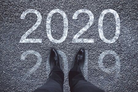 Businessman standing on asphalt with drawing new year 2020. Future old year conceptの写真素材