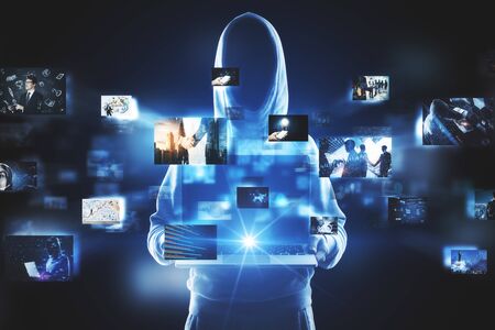 Hacker holding laptop with digital pictures on blurry dark background. Media photo gallery background. Multiexposureの写真素材