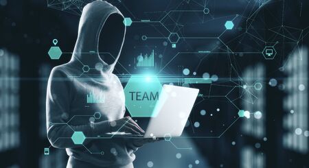 Hacker holding laptop with business report. Team and device concept.