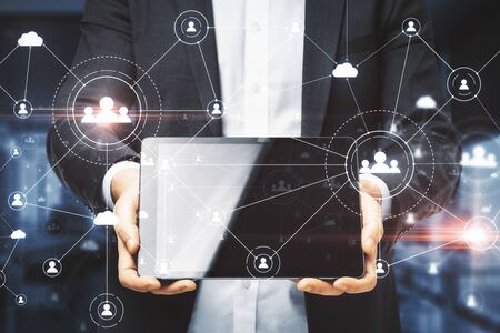 Businessman holding digital tablet in hand with creative social network interface and glowing human...