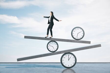 Businesswoman walking on scales on blue sky background. Business and deadline concept.の写真素材