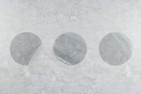 Three transparent plastic round sticker on concrete wall. Presentation concept. 3D Renderingの写真素材