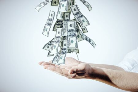 Businessman puts hands to falling dollar bills.  Business and financial success concept.の写真素材