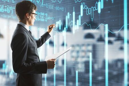 Businessman drawing business statistics hologram on virtuale screen. Success and startup concept.