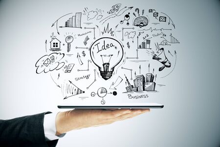 Hand holding digital tablet with abstract success scheme. Business and startup concept. Close upの写真素材