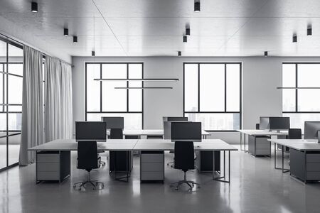 Contemporary grey coworking office interior with equipment and computers on desktop, other pieces of furniture and daylight. 3D Renderingの写真素材