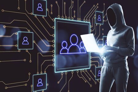 Hacker using laptop and glowing human resource interface on virtual screen. Communication and...