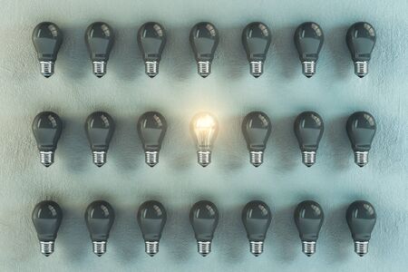 Many gray light bulbs in a row and one glows. Success and startup concept. 3D Renderingの写真素材