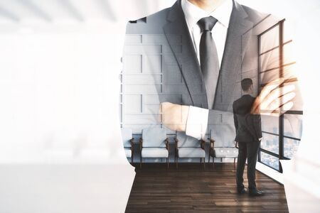 Businessman standing in waiting room interior with double exposure of businessman in suit. Leadership and job conceptの写真素材