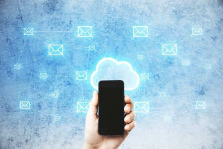 Hand using smartphone and glowing cloud email map hologram. Cloud computing, newsletter and...