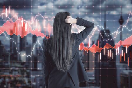 Pensive businessman looking on stock chart and blurry night city view. Finance and research concept. Multiexposureの写真素材