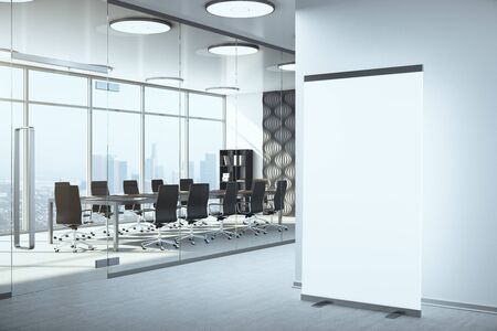 Modern meeting interior with blank vertical poster on wall and daylight.  Workplace and lifestyle...