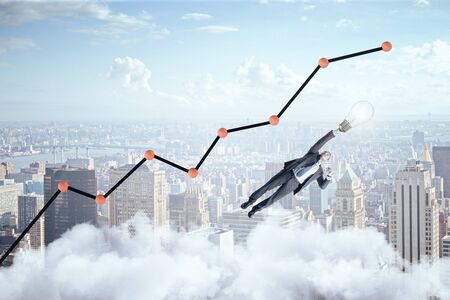 Businessman flying with lamp over the city and business charts and stock analytics. Success and startup concept.の写真素材