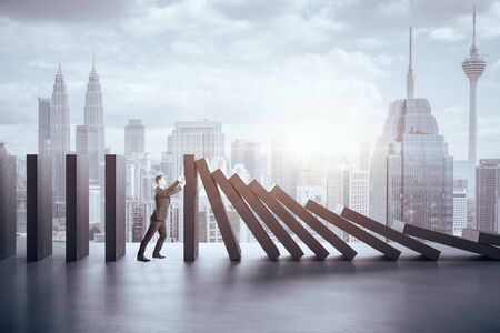 Businessman in suit pushing blocks on panoramic city  background. Business and challenge concept.の写真素材