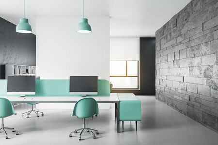 Modern coworking office interior with computers on table and blank brick wall. Workplace and company concept. 3D Renderingの写真素材