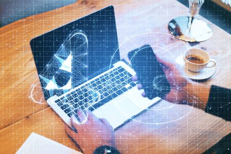 Hands using laptop and smartphone on desktop with abstract 4G network hologram. Internet and web speed concept. Multiexposureの写真素材
