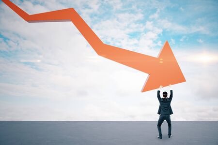 Businessman holding stock crash red arrow on cloud background. Business and financial crisis...