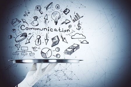 Businesssman hand holding plate with drawing communication business sketch. Communication and marketing concept.の写真素材