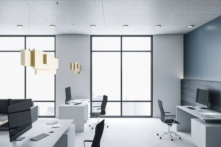 Luxury coworking office interior with computers on table and city view. Workplace and company...