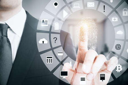 Businessman scanning finger print in blurry interior background. Access, password and protection...