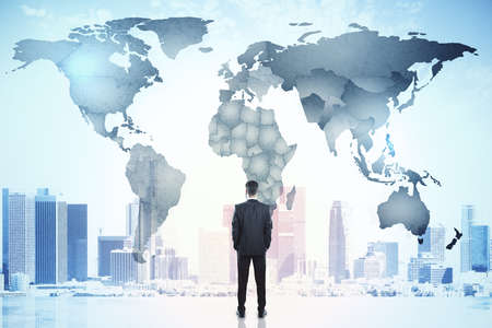 Businessman looking on city and digital world map hologram. Global network and communication concept. Double exposure.の写真素材