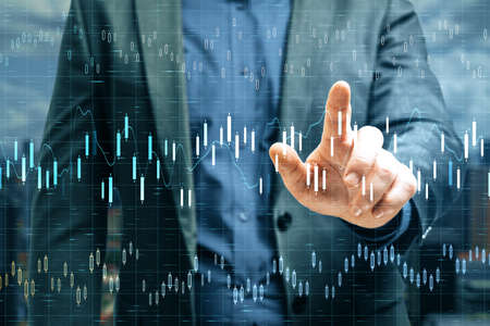 Businessman hand pointing at stock chart interface on virtual screen. Trade and finance concept....