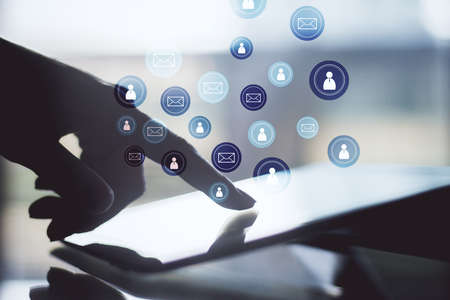 Hand using digital tablet with glowing email network symbol. E-mail marketing, message and...