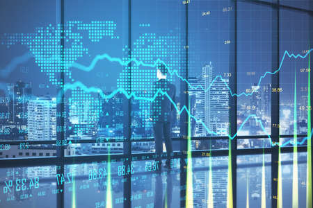 Thoughtful businessman standing in abstract office interior with glowing forex chart and night city...