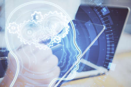 Side view of hands using laptop and tablet with glowing head with cogs. Data and machine learning...