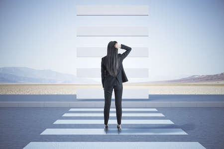 Businesswoman looking at a pedestrian crossing going up. Motivation and challenge concept.の写真素材