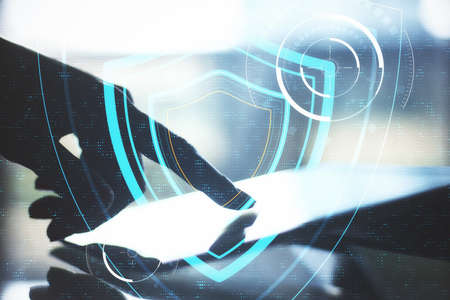 Hand using tablet on table and digital system security interface. Business and security concept....