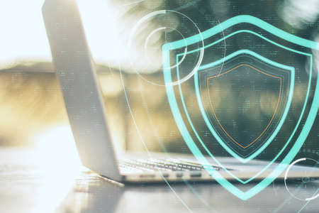 Laptop computer on table with digital shield. Safety and protection concept.