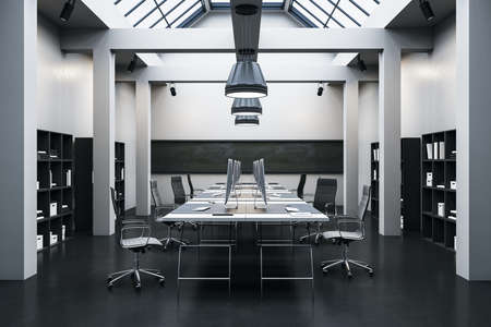 Modern coworking office room with computers and shelf with books. Workplace and corporate concept....