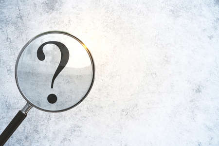 Magnifying glass search drawing question mark sign on concrete wall. Business and challenge concept....