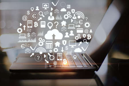 Workplace with laptop on table and cloud computing diagram. Cloud computing and communication...