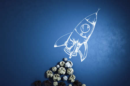 Crumpled papers and drawn rocket on blue background. Success and startup concept. 3D Rendering