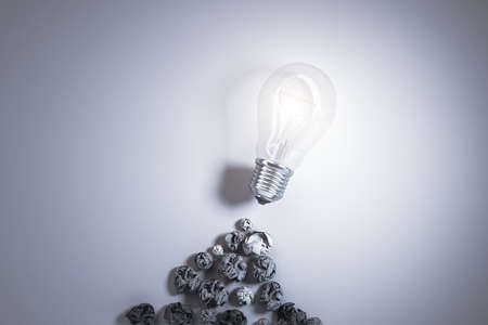Crumpled paper and lamp on gray background. Success and startup concept. 3D Rendering