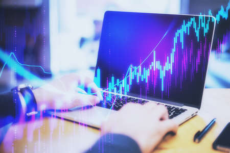 Businessman hands typing on keyboard laptop with business charts. Finance and trade concept....