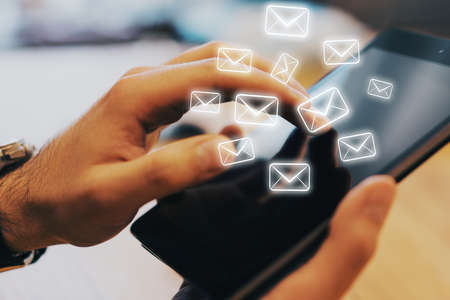 Businessman hand using digital tablet with email icon. E-mail marketing concept