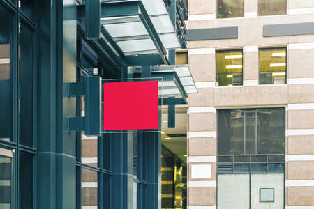 A red square sign with blank space for your design on the wall of a modern shopping center, mockupの写真素材