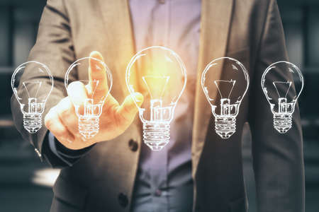 Businessman hand pushing five drawing light bulbs. Success and startup concept. Close upの写真素材