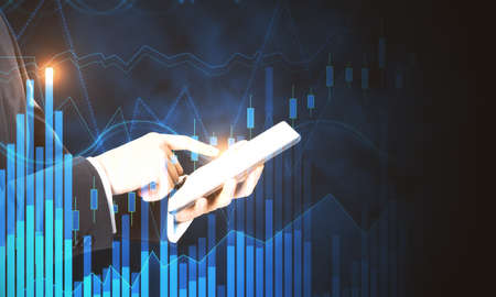 Business trading concept with man using digital tablet at financial graphs background.Double...