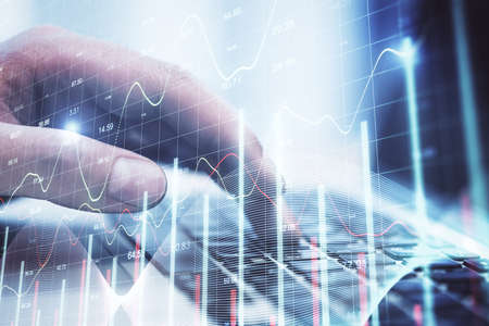 Hand of businessman typing on keyboard laptop with business chart. Finance and trade concept....