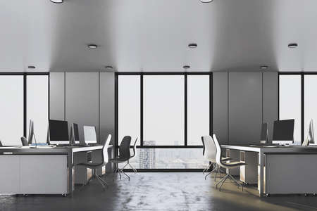 Comfortable office interior with many computers on table and megapolis city view. Coworking...