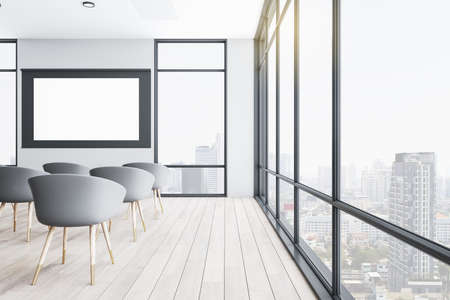 Modern presentation auditorium with empty white screen and panoramic city view. Conference and...