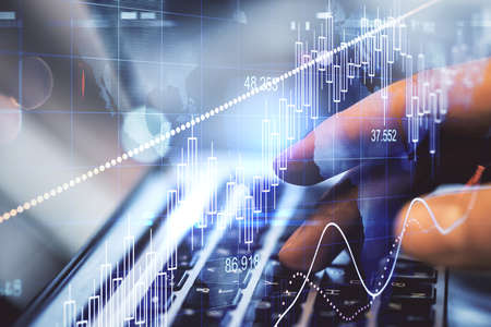 Hand of businessman typing on keyboard laptop with business analytics hologram. Finance and trade...