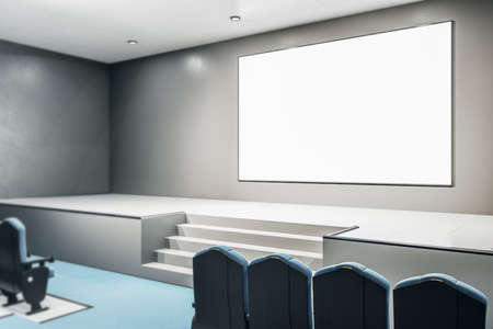 Big blank white poster on gray wall in conference room with podium and row of seats on blue carpet. Mockup. 3D renderingの写真素材