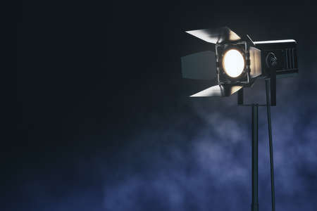 Illuminating black spotlight floor lamp among smoke at abstract dark background. Mockup. 3D...
