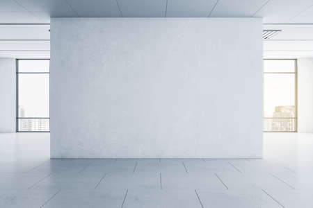 Light blank concrete wall in the center of empty hall room with big windows and city view. Mockup....